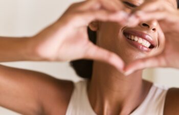 Dental Care Smile. Woman Making a Heart Shape with Her Hands, Emphasizing Happiness, Positivity, and Oral Health. Perfect for Wellness and Lifestyle Themes.